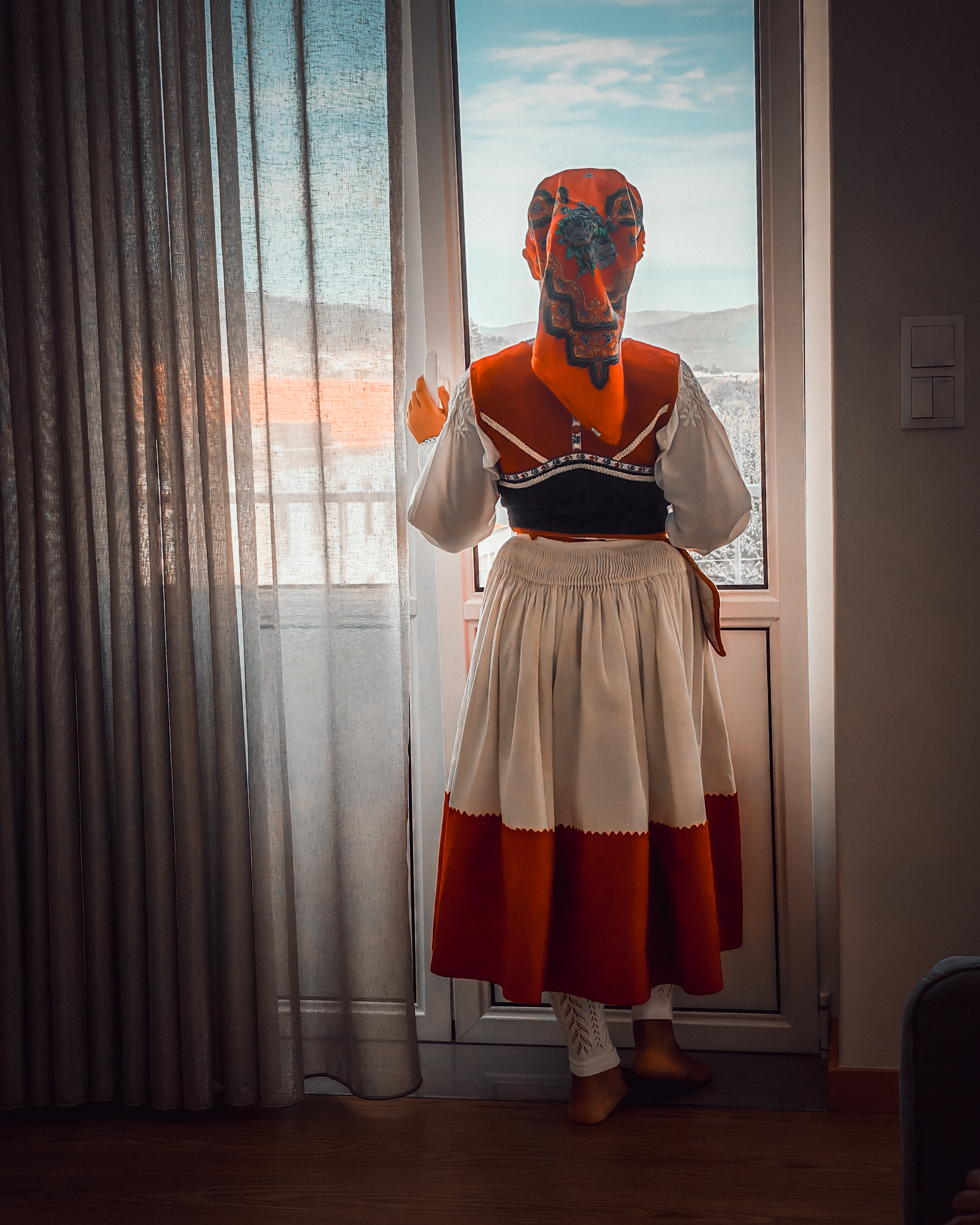 Traditional folk dress by window