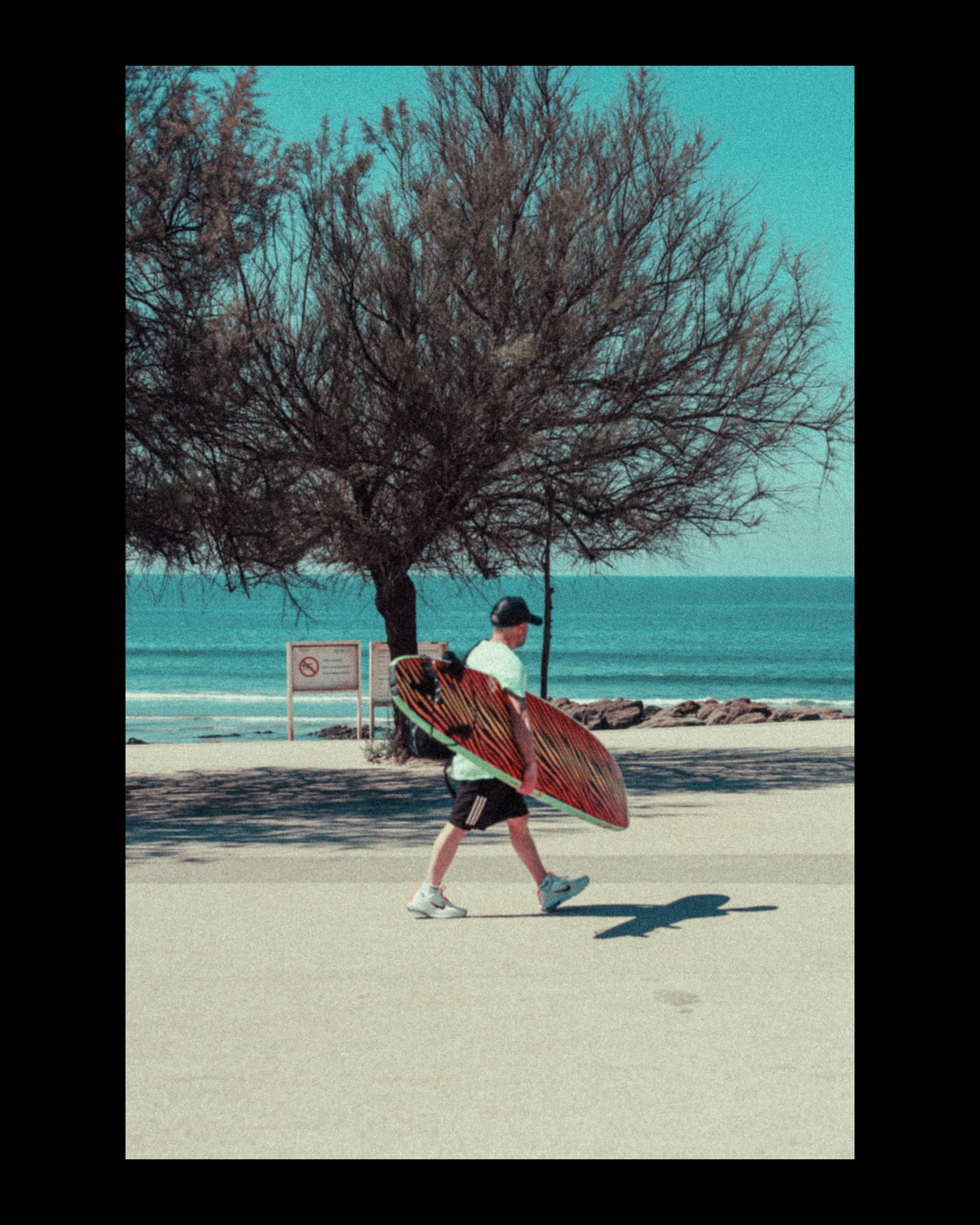 Surfer walking by coastal promenade